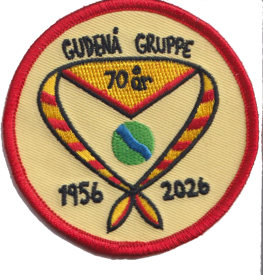Broderet rundt mærke 'Gudenå Gruppe 70 år 1956–2026' med tørklæde og rød kant